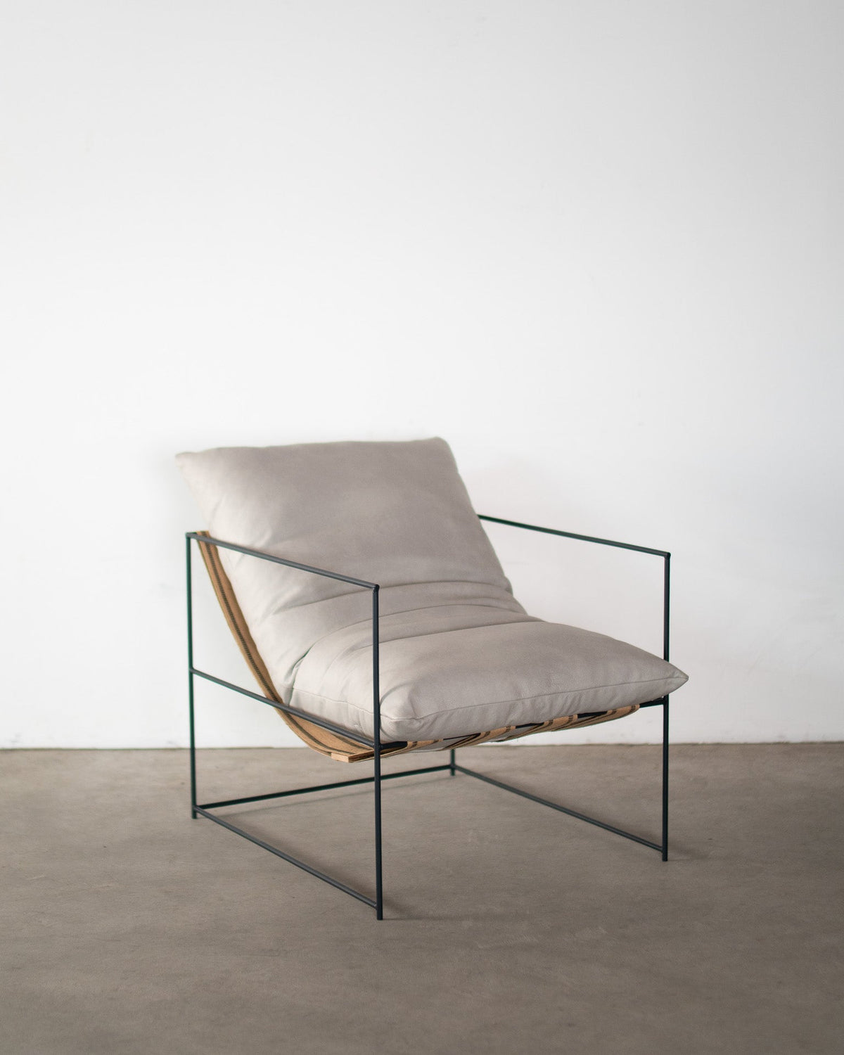 Modern chair with beige cushion on a plain background