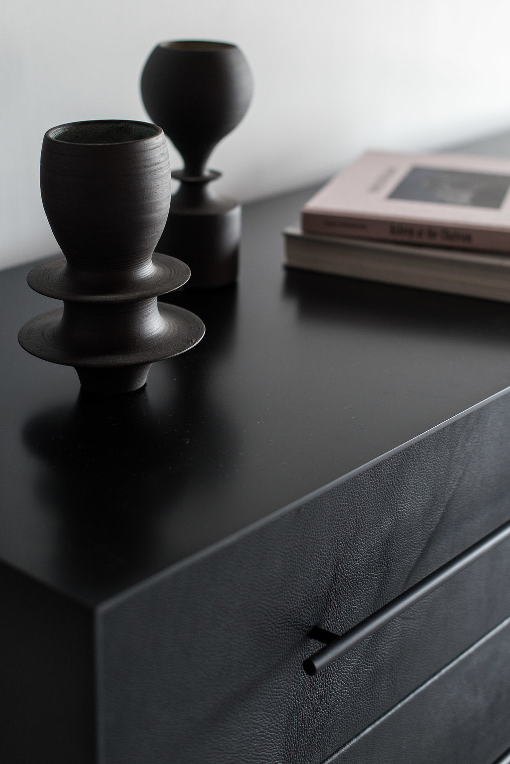 close up of Left corner of steel casing and black leather drawer
