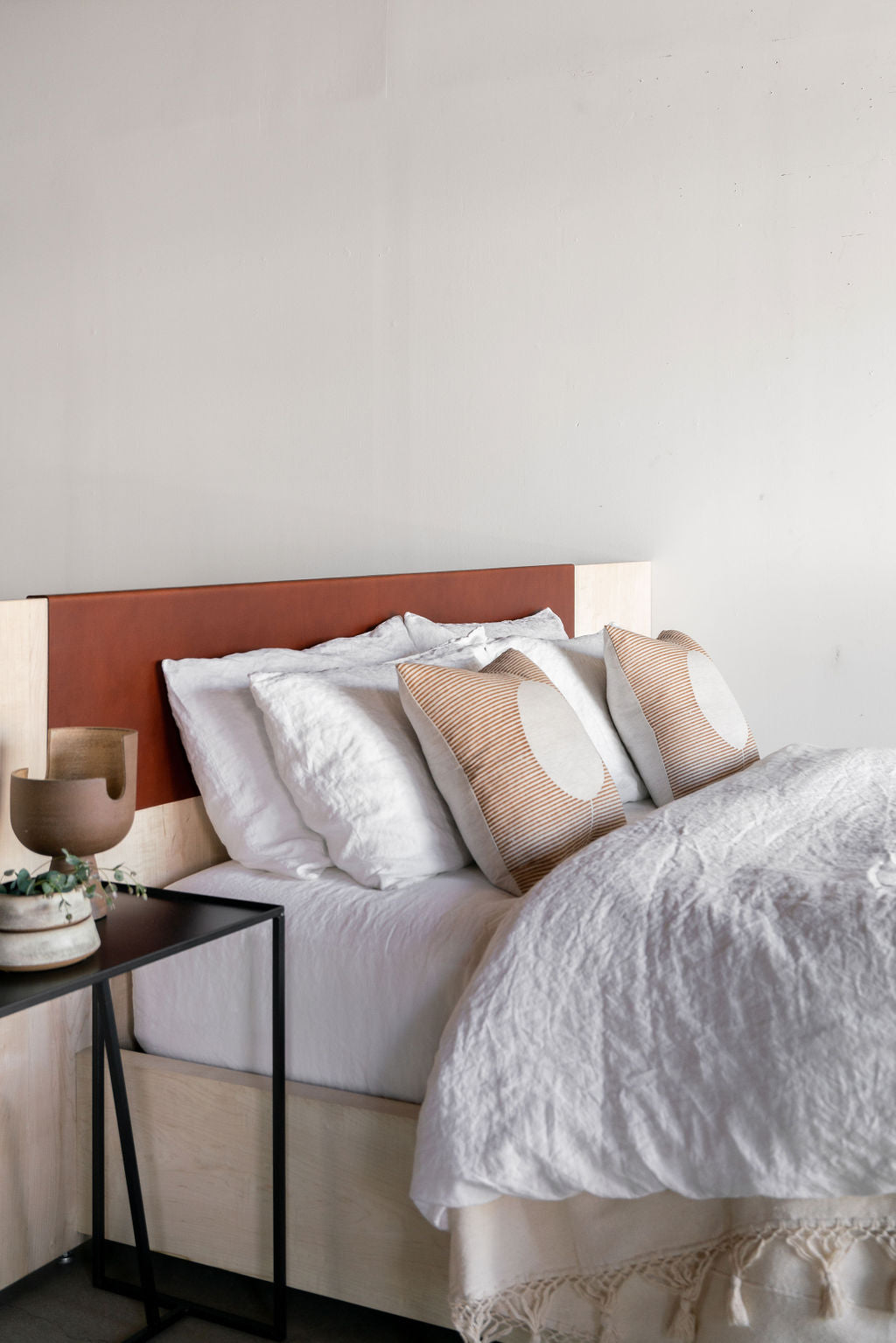Carter bed- left side angle shot, all wooden bed frame with leather detail on headboard